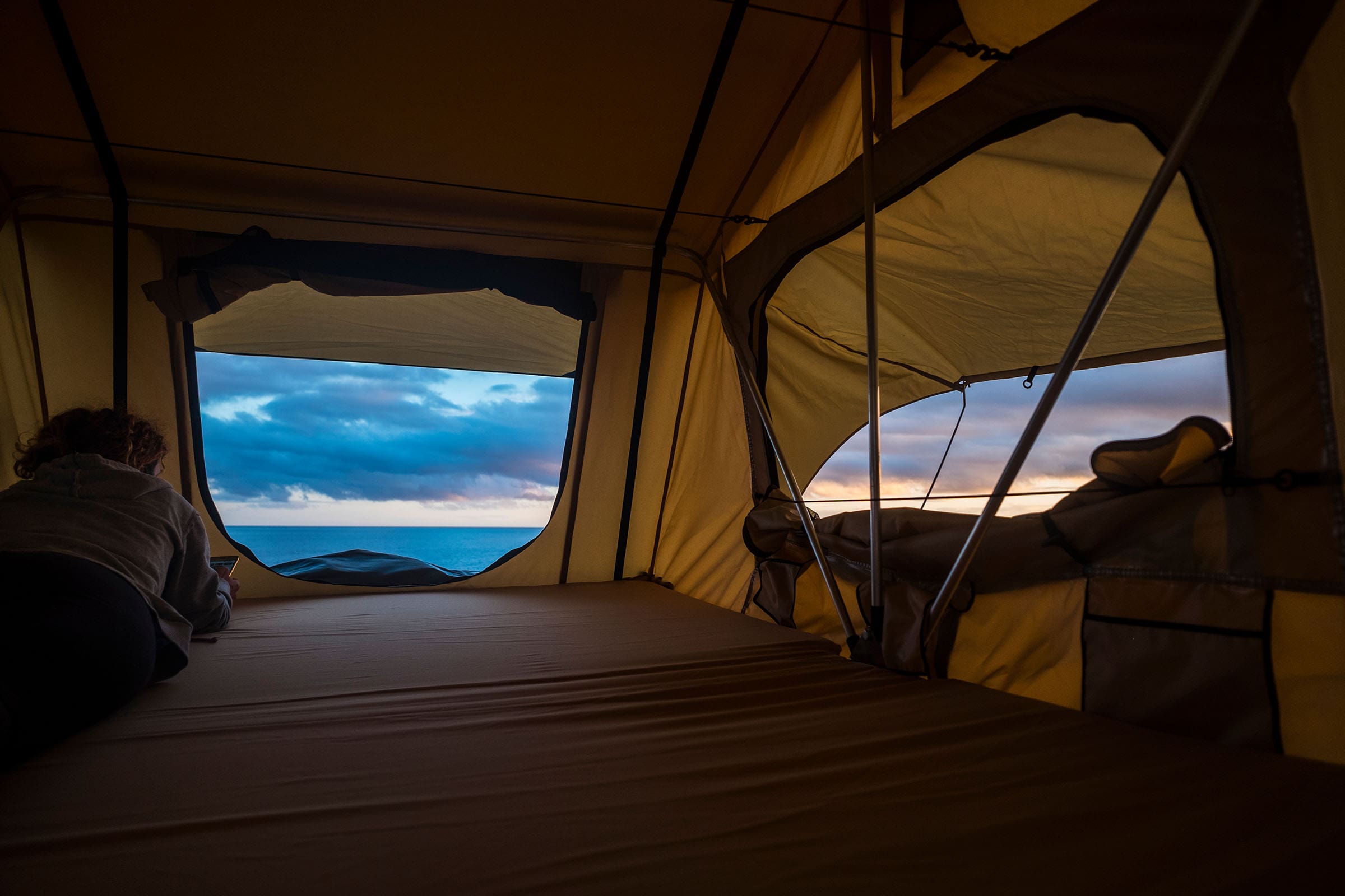 Rooftop tent with view of sea through open door