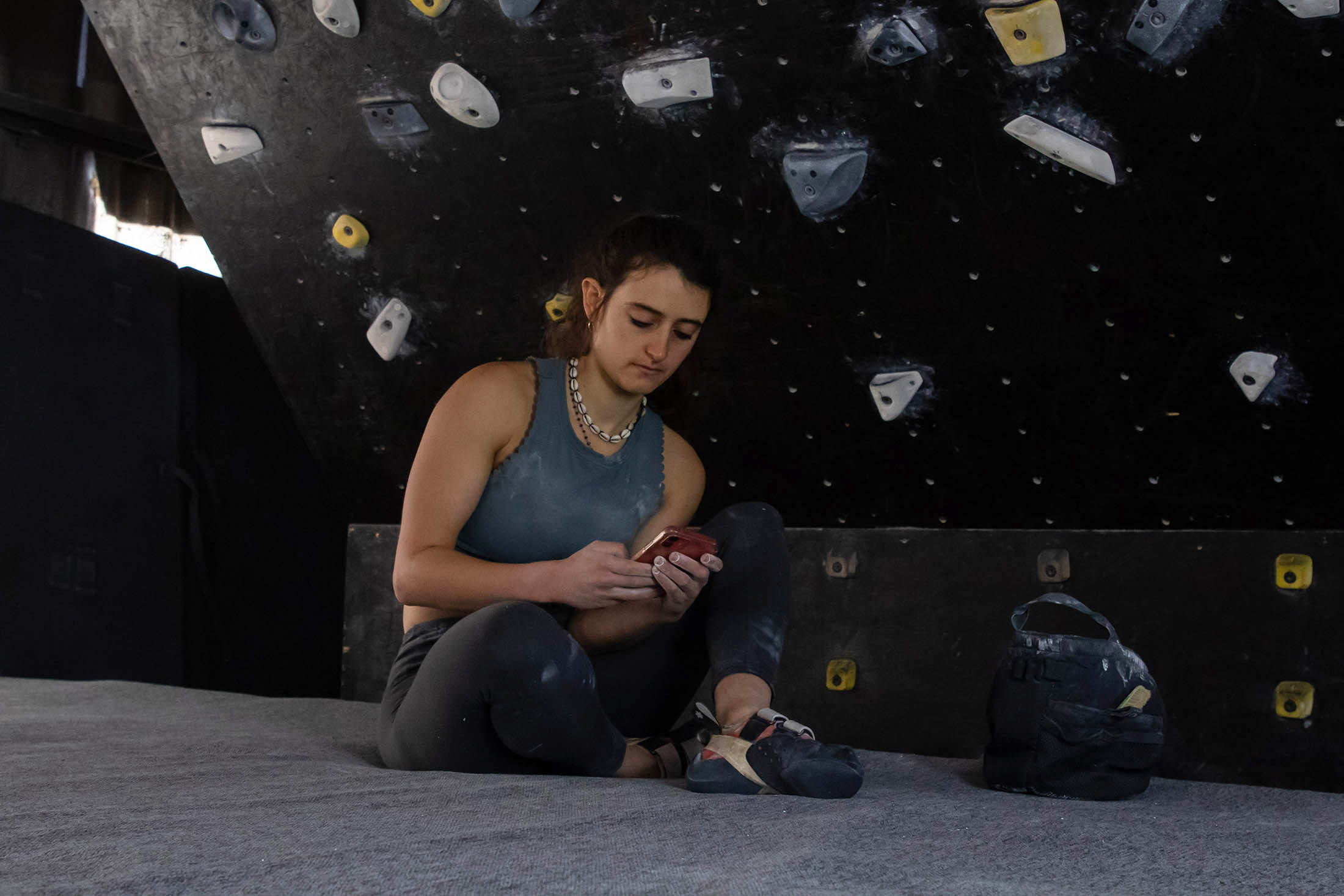 Climber using phone to select Moon Board problem