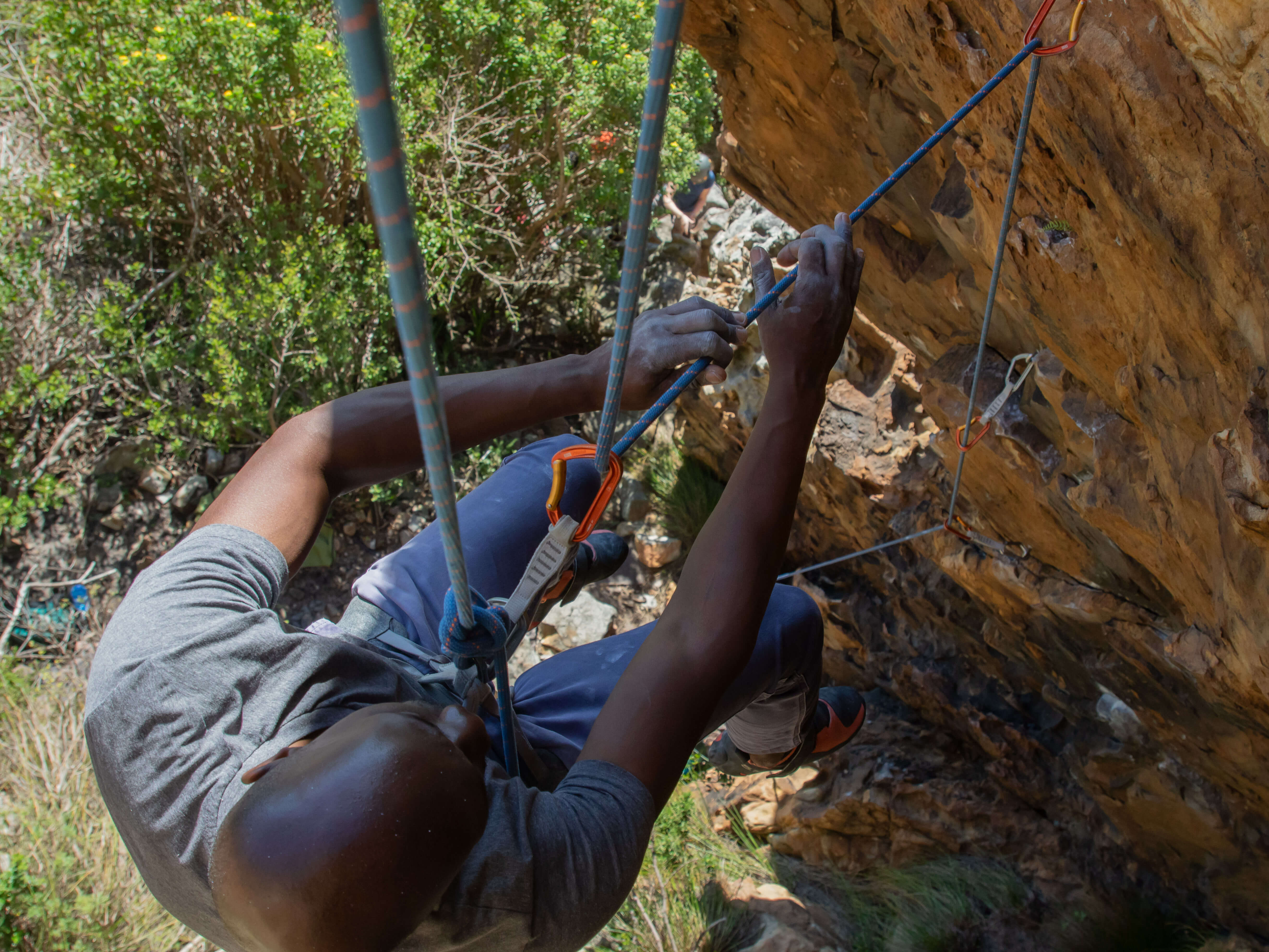 climber tramming down rope while retrieving quickdraws
