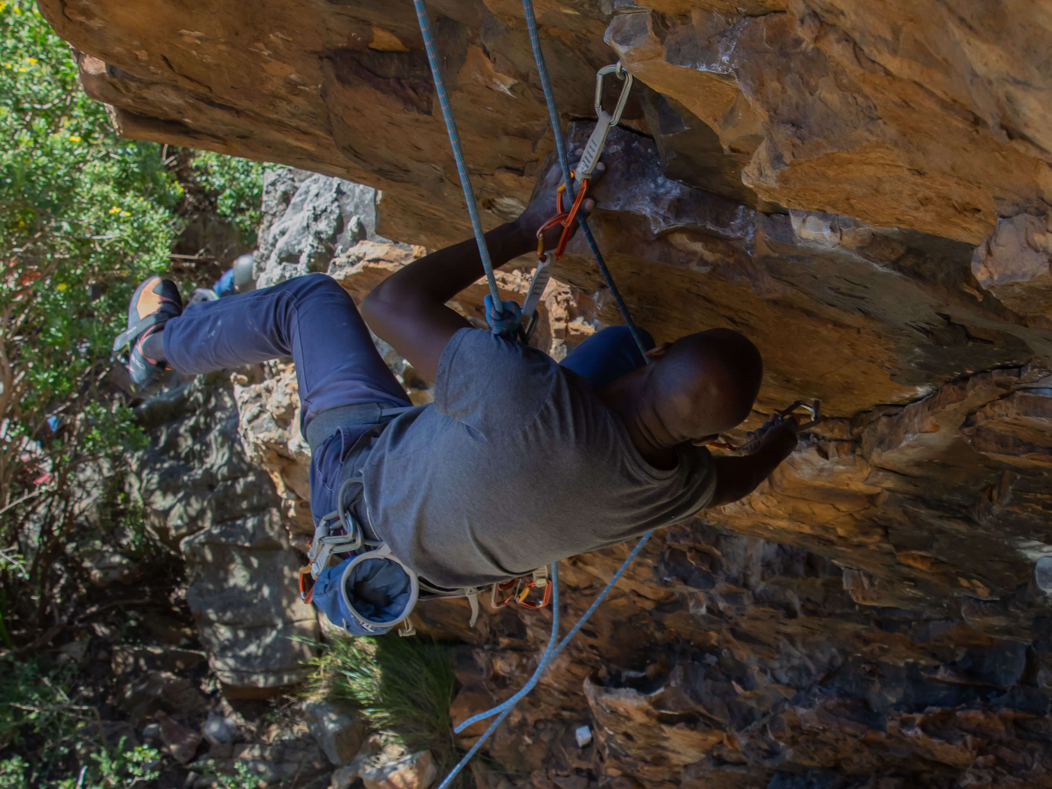 climber cleaning bottom quickdraw from above