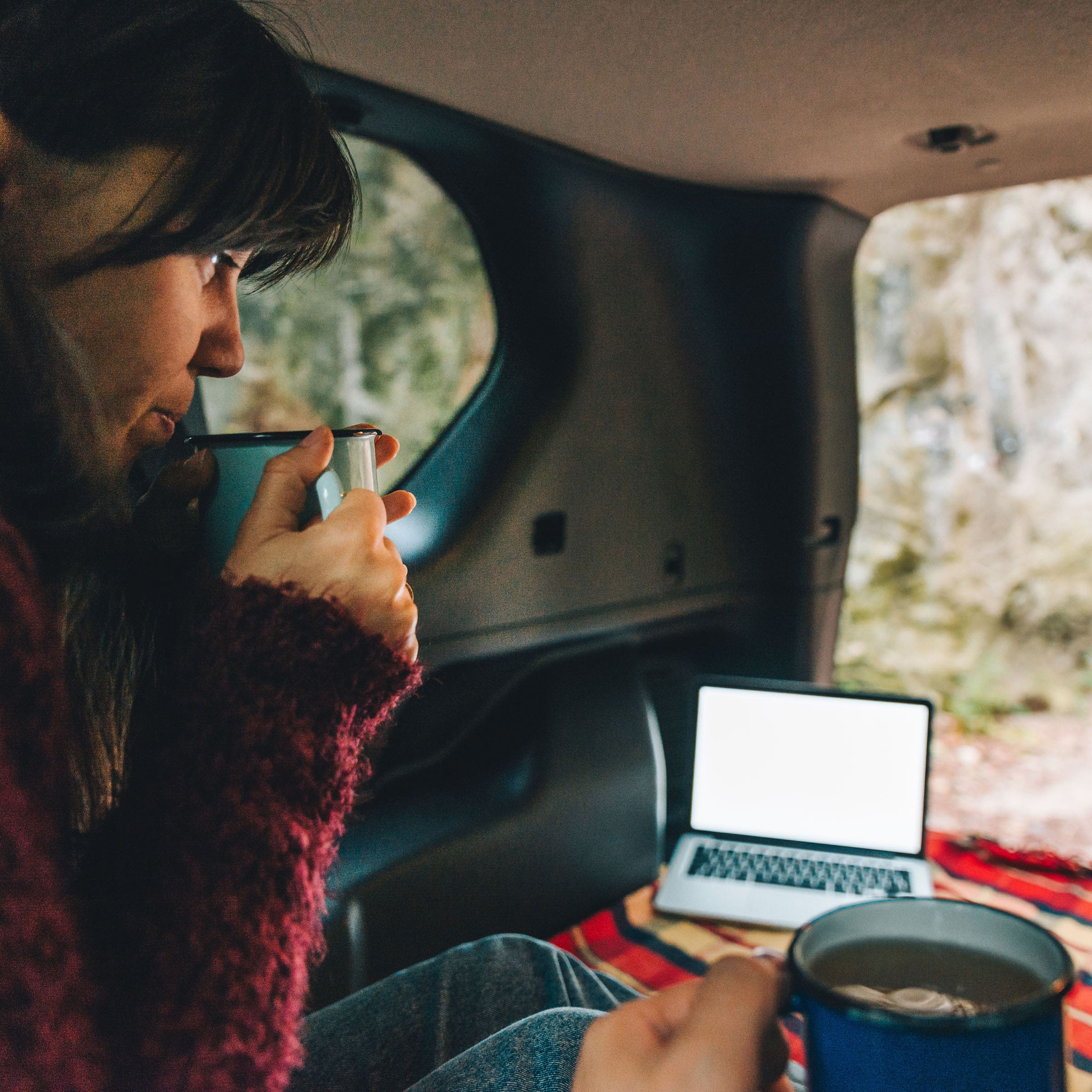 woman working on laptop in back of SUV