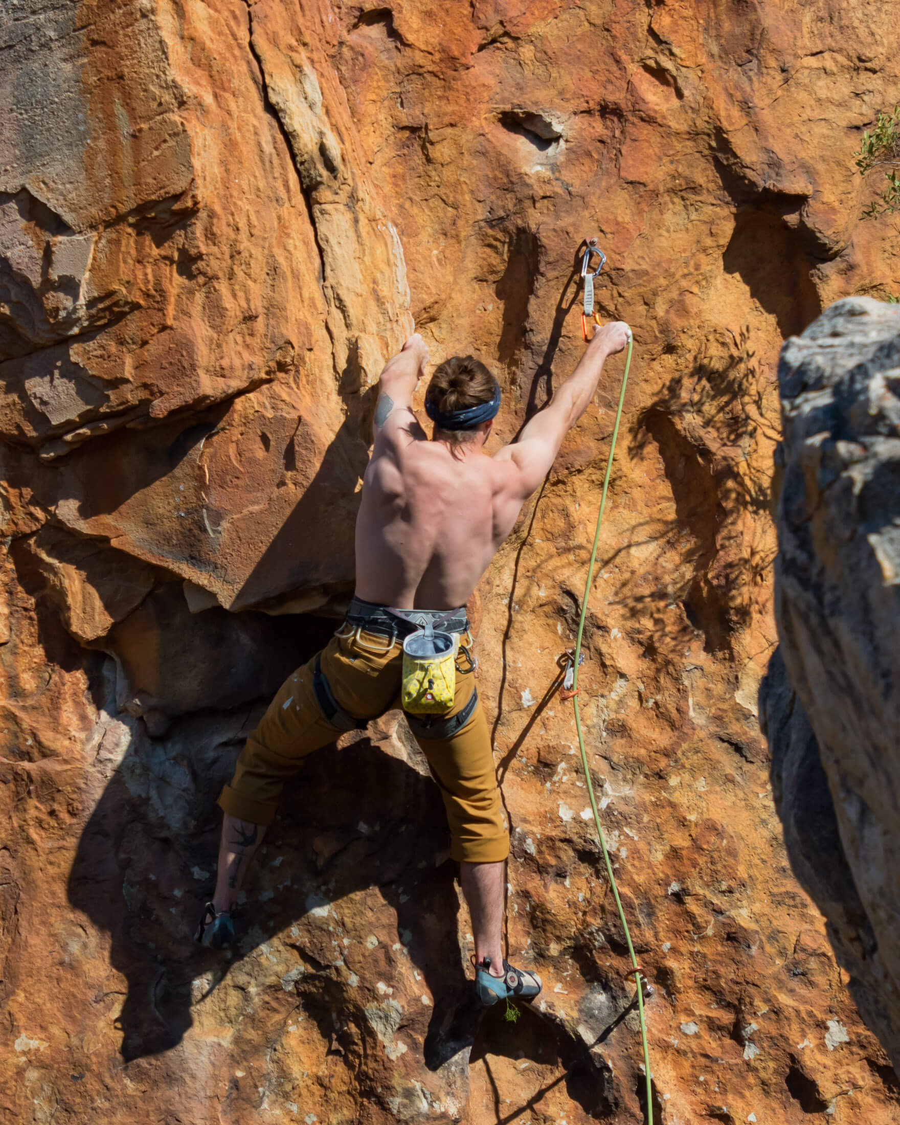 sport climber clipping the first few bolts on a route