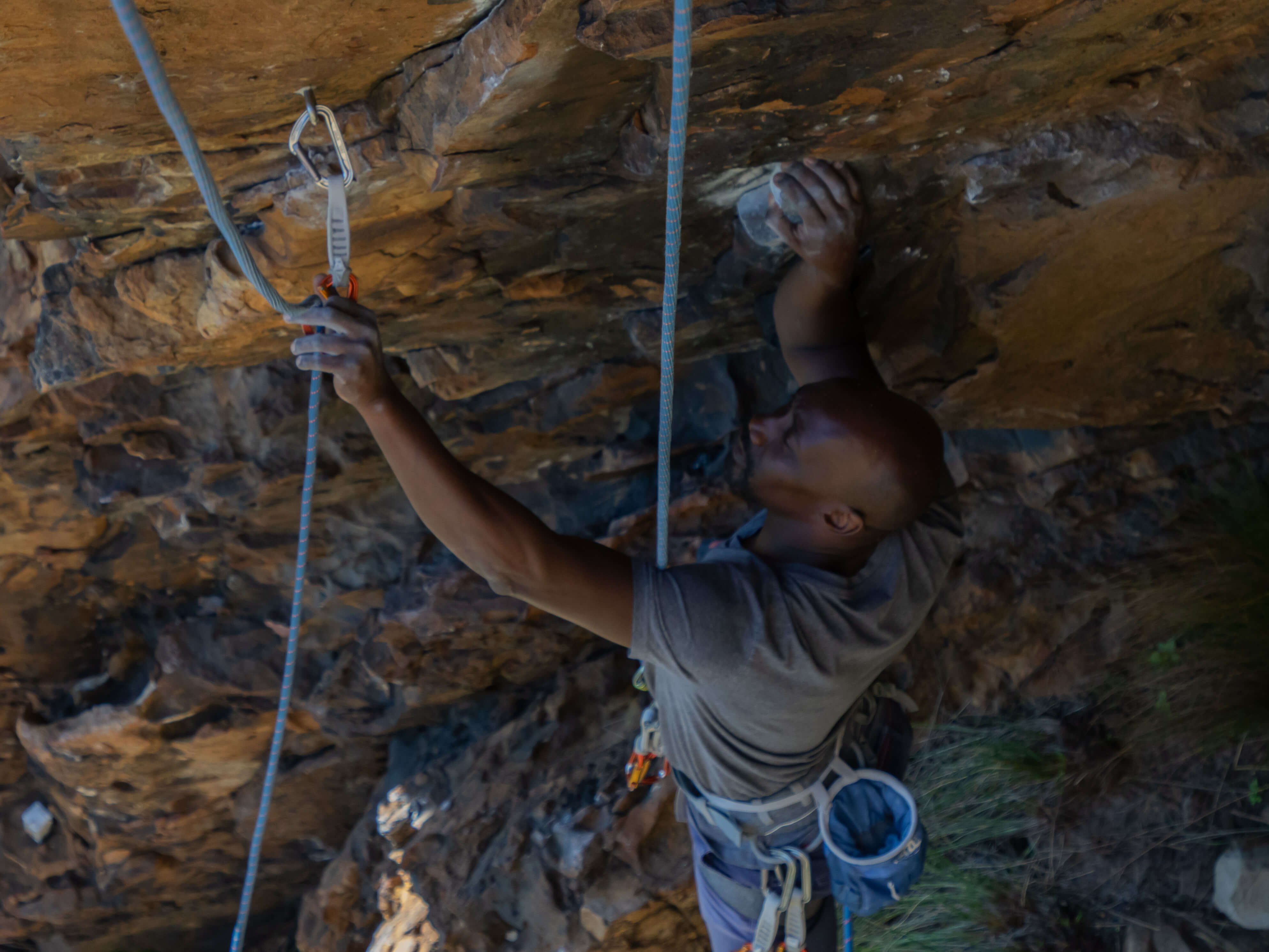 climber removing bottom quickdraw from ground