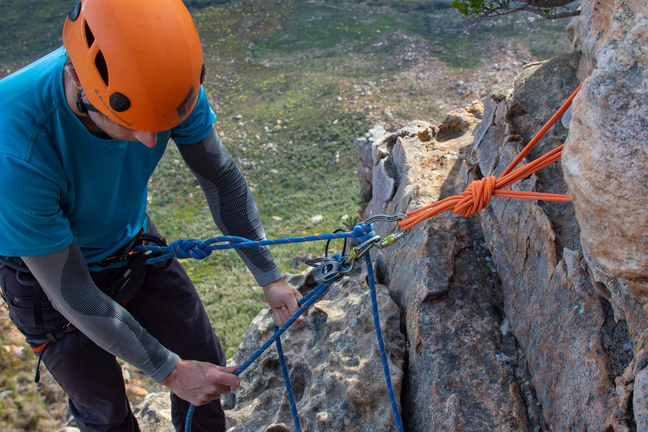 climber belaying off a trad anchor