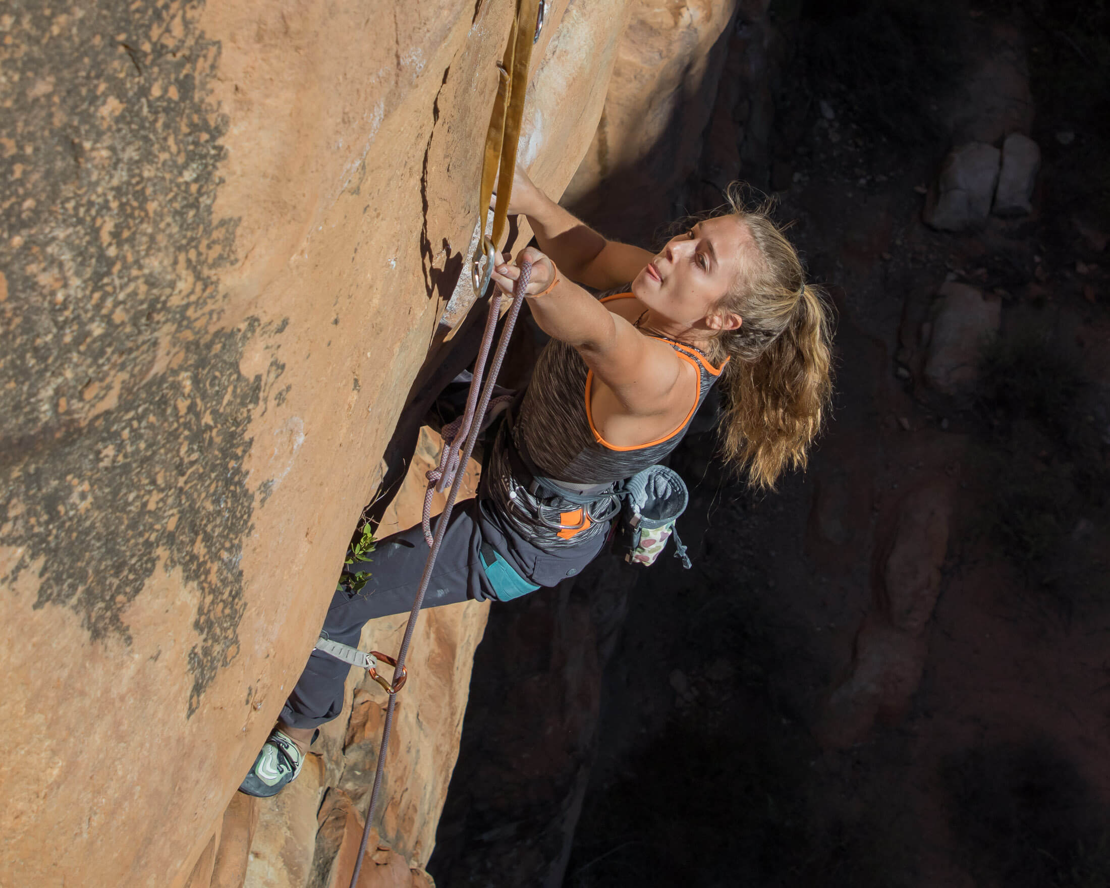 climber clipping a quickdraw on a sport route