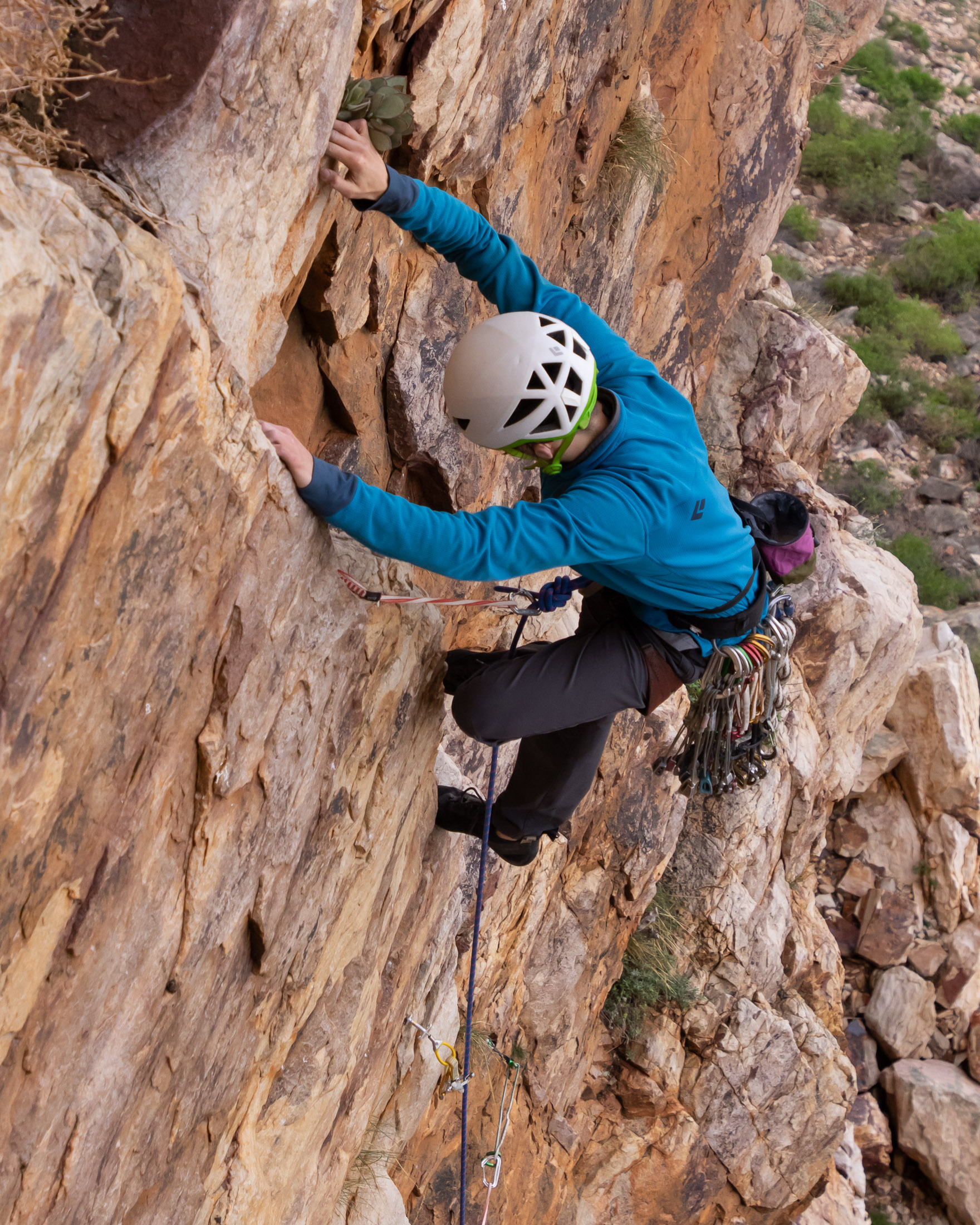 climber pulling moves above first 3 pieces of gear