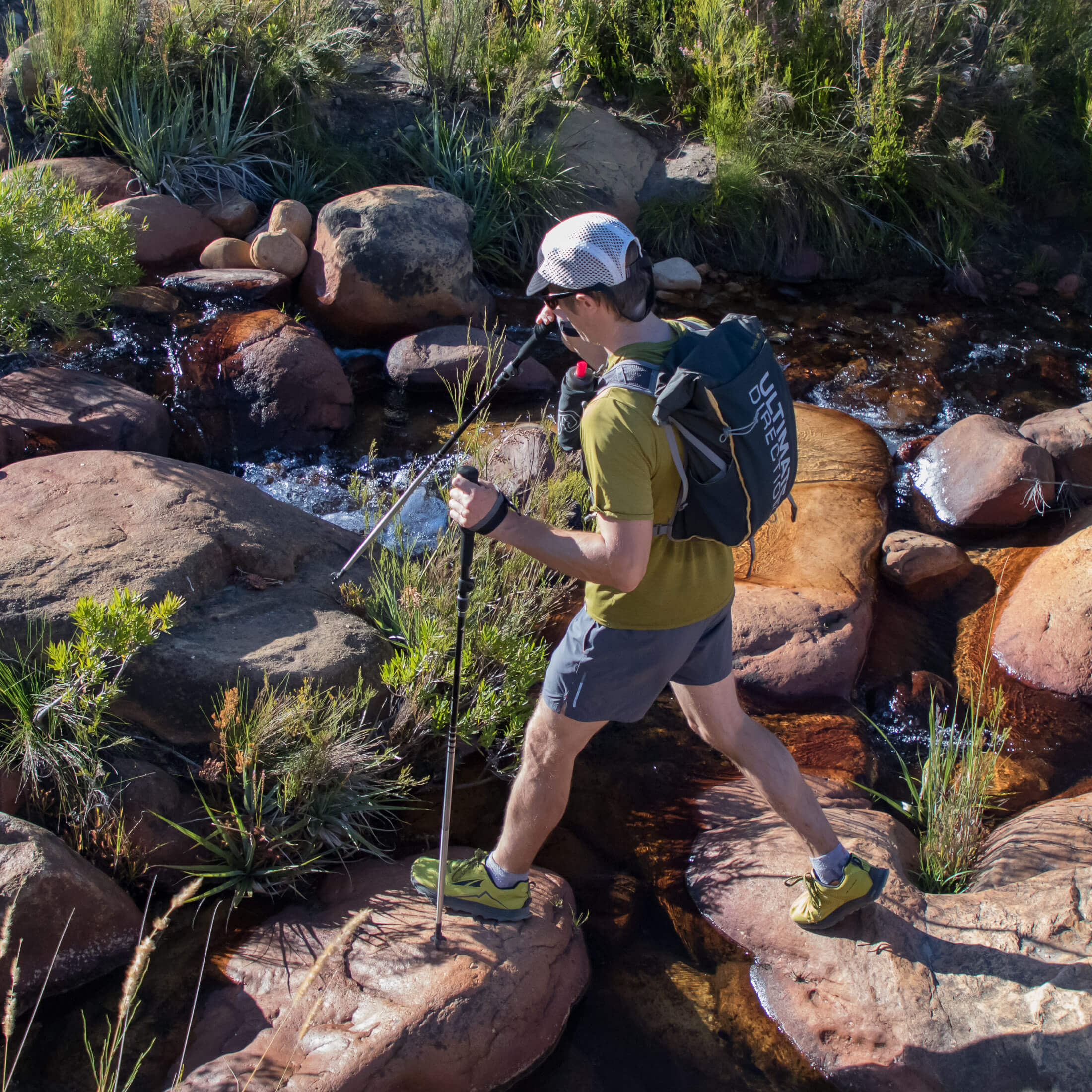 hiker crossing a stream while fastpacking