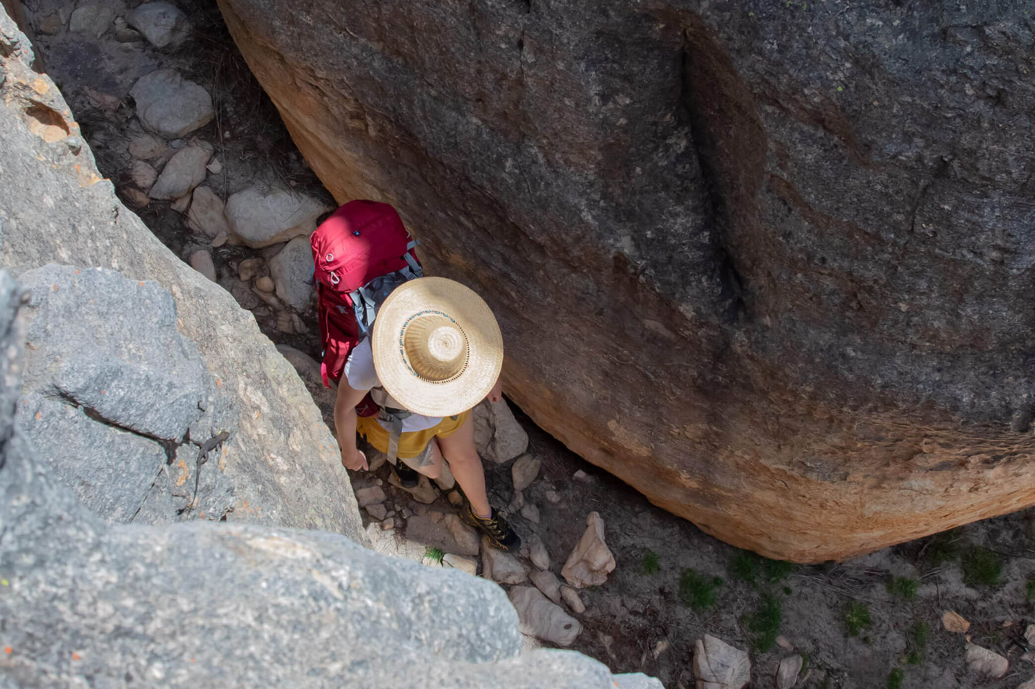 Hiker passing through narrow rock passage