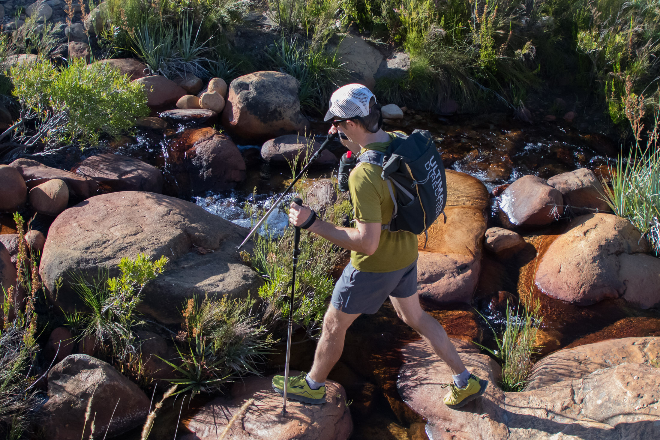fastpacking hiker crossing stream