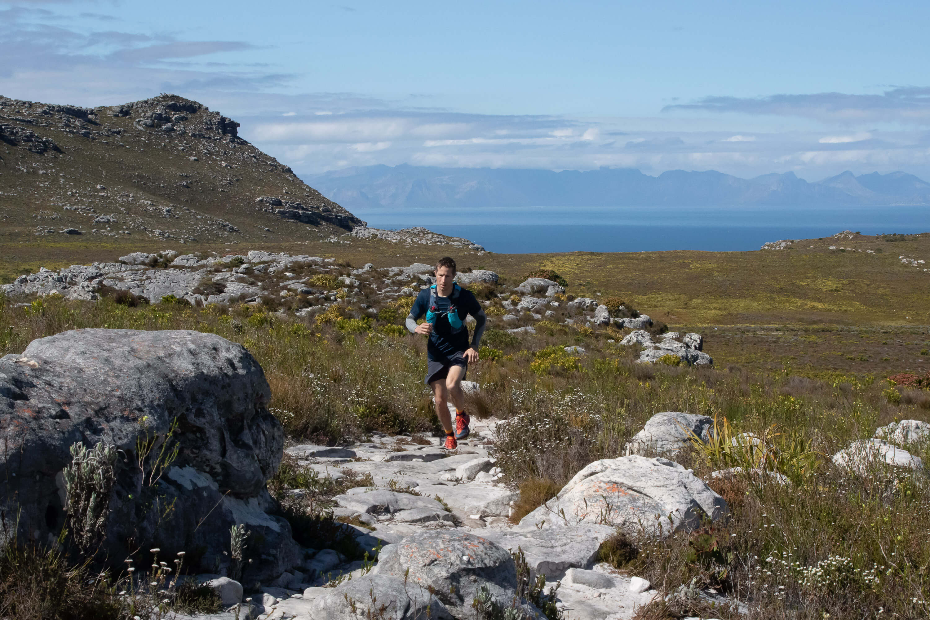 running a trail with the sea in the distance