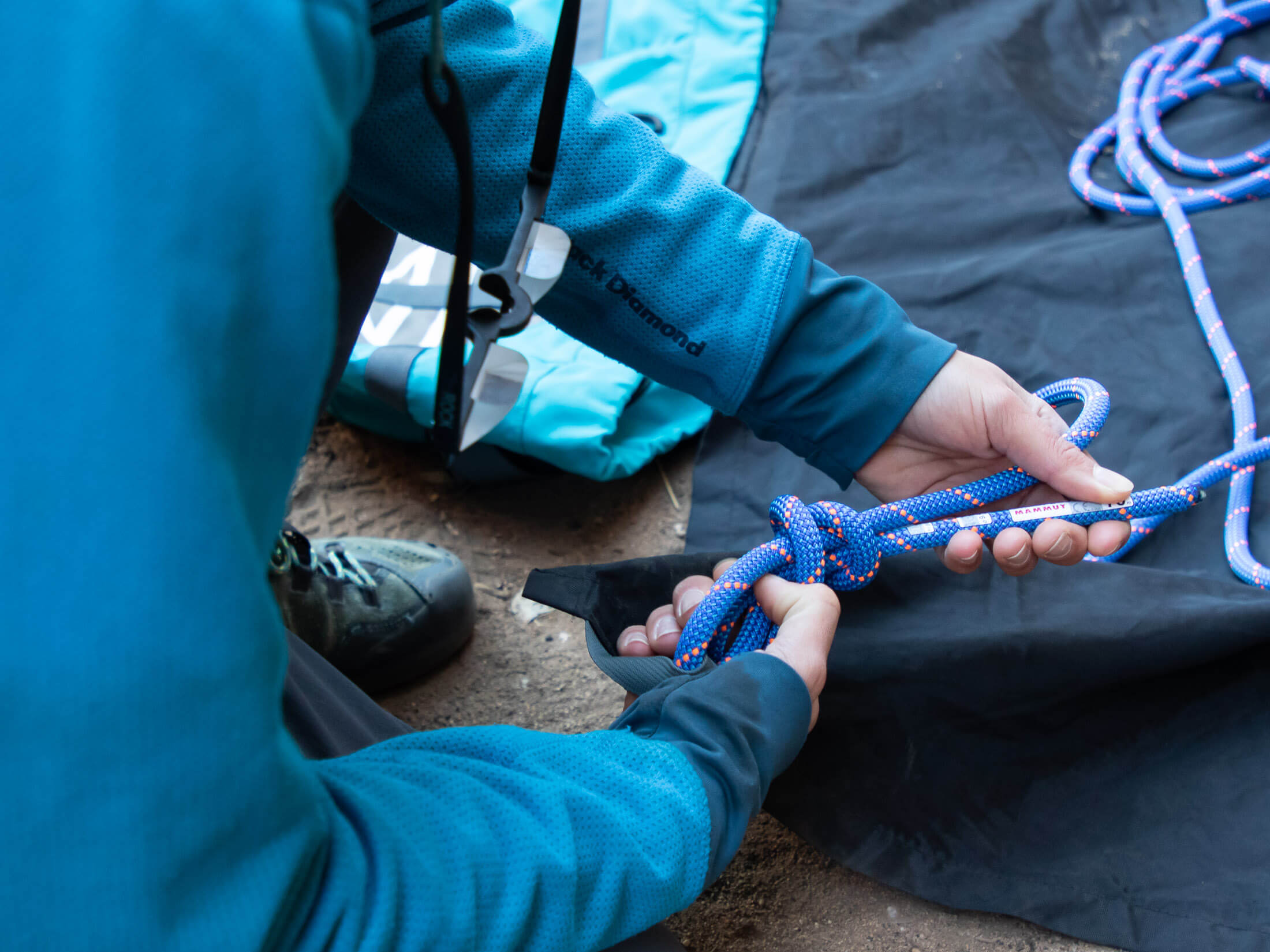 climber tying rope to rope bag