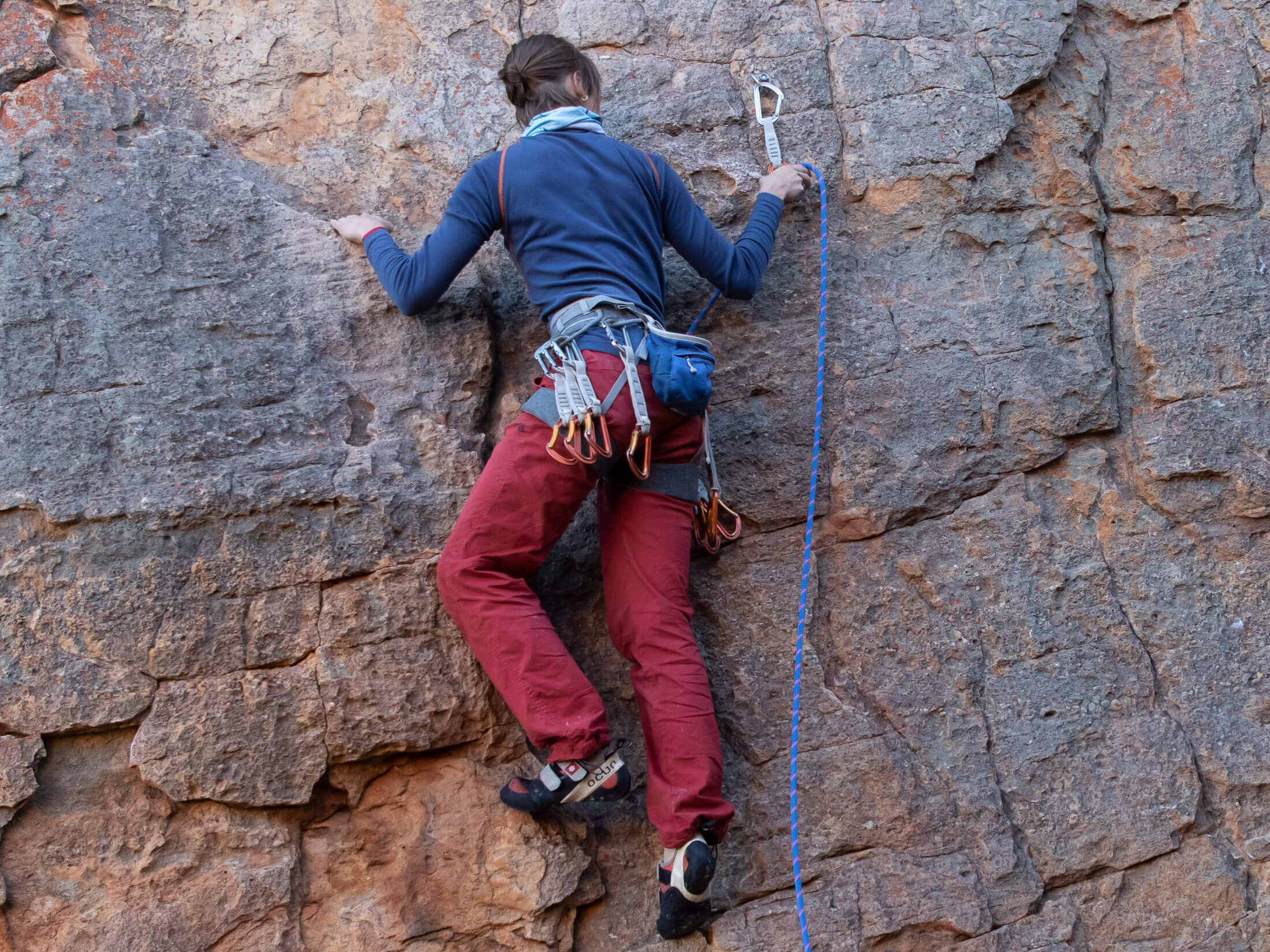 climber clipping rope through quickdraw 