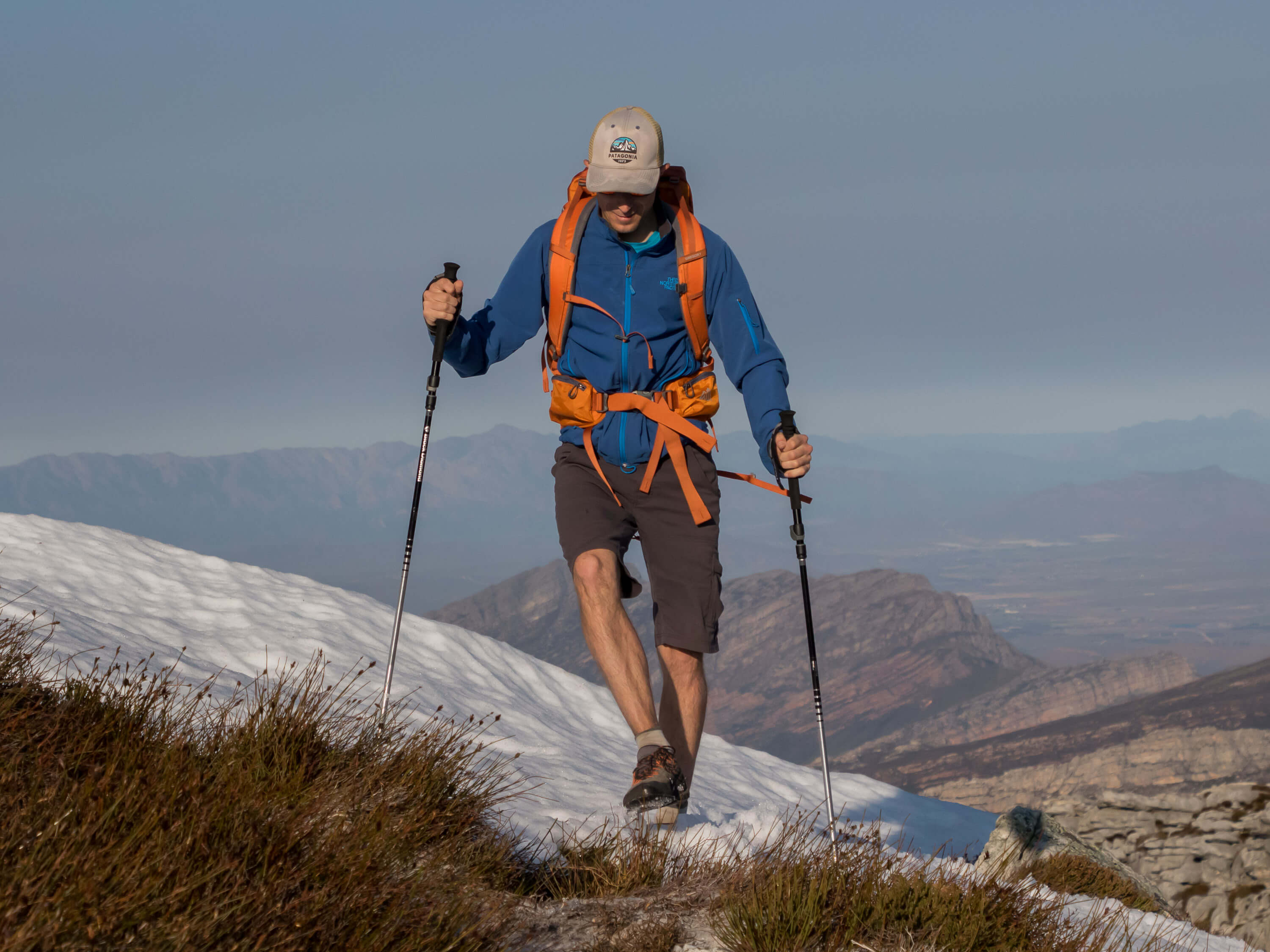 traversing snow covered slope with trekking poles