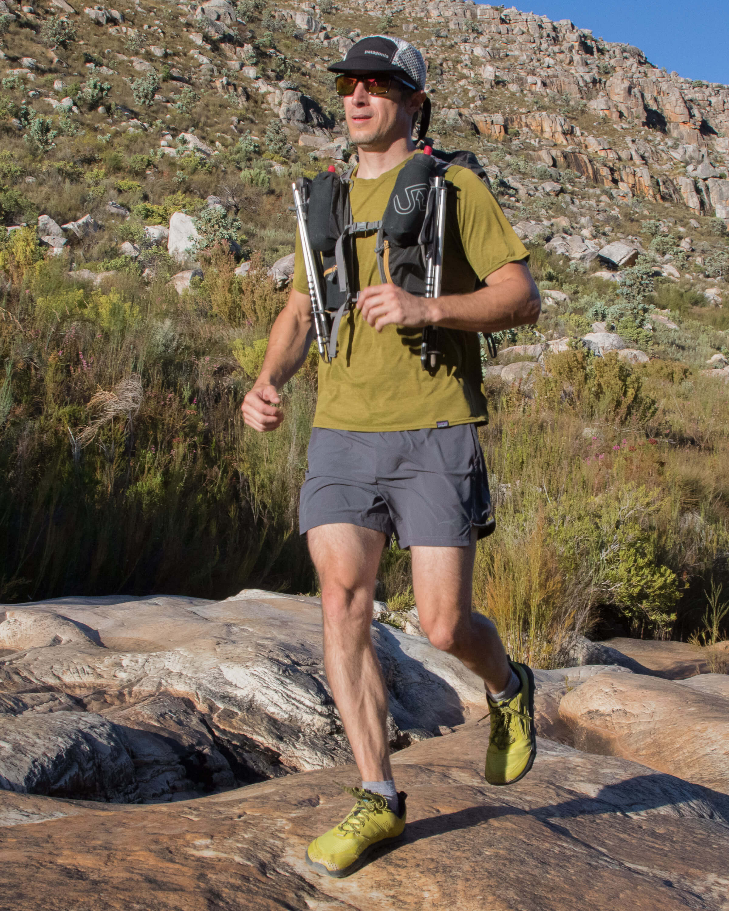 running with trekking poles attached to vest