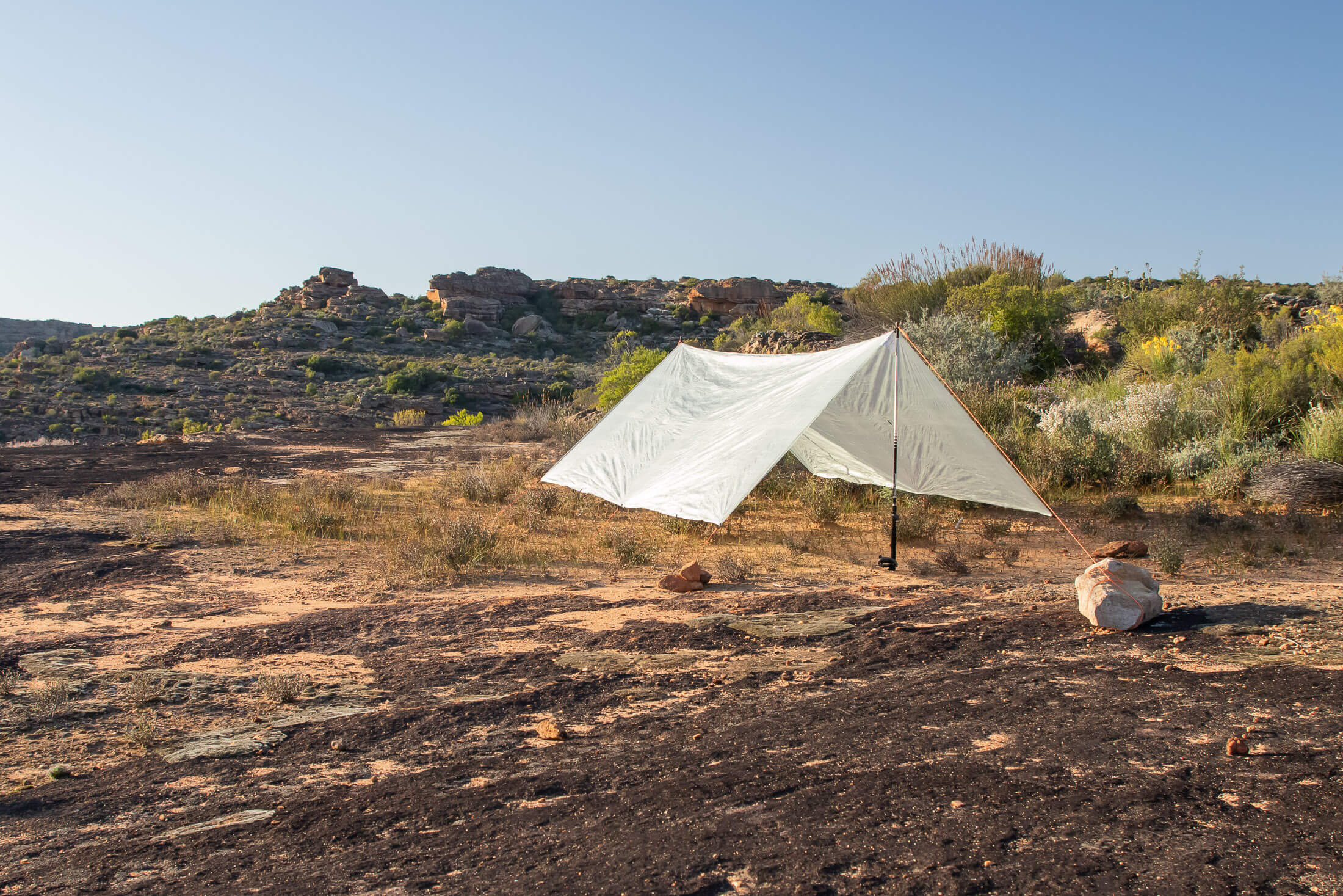 ultralight tarp set up on rocky plateau