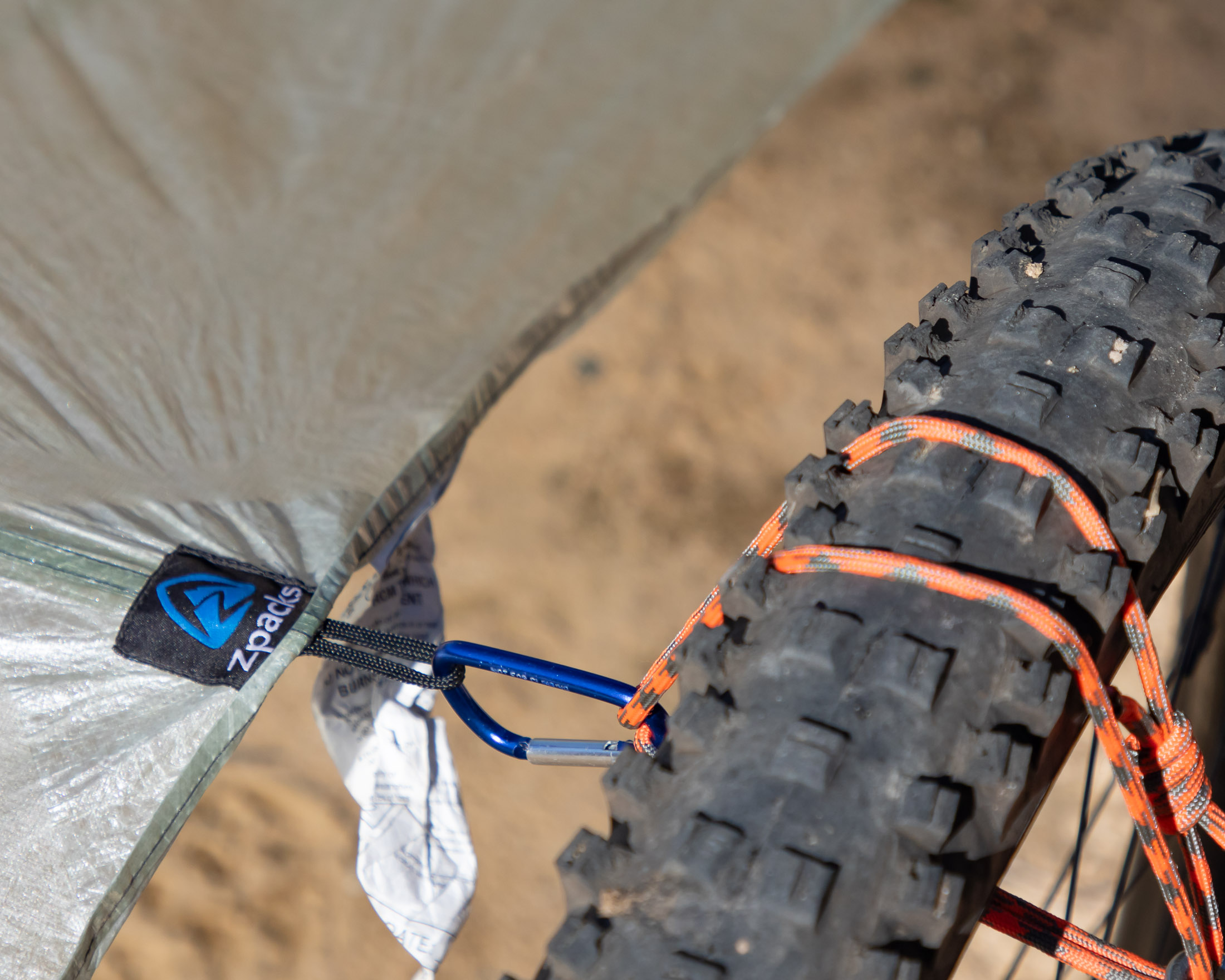 tarp secured to bike wheel with accessory cord
