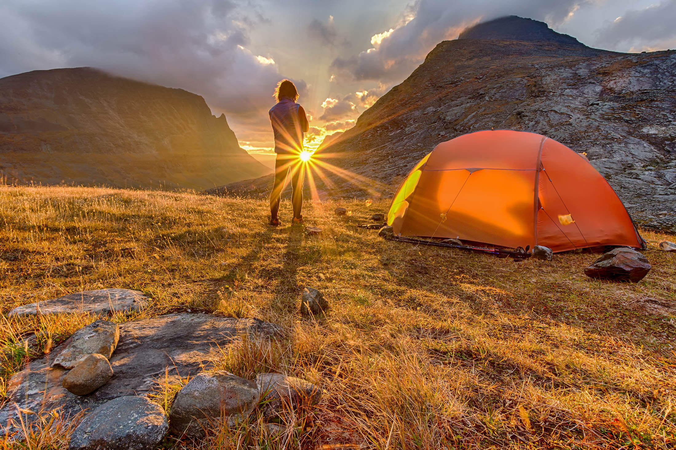 camper watching the sunrise from hilltop