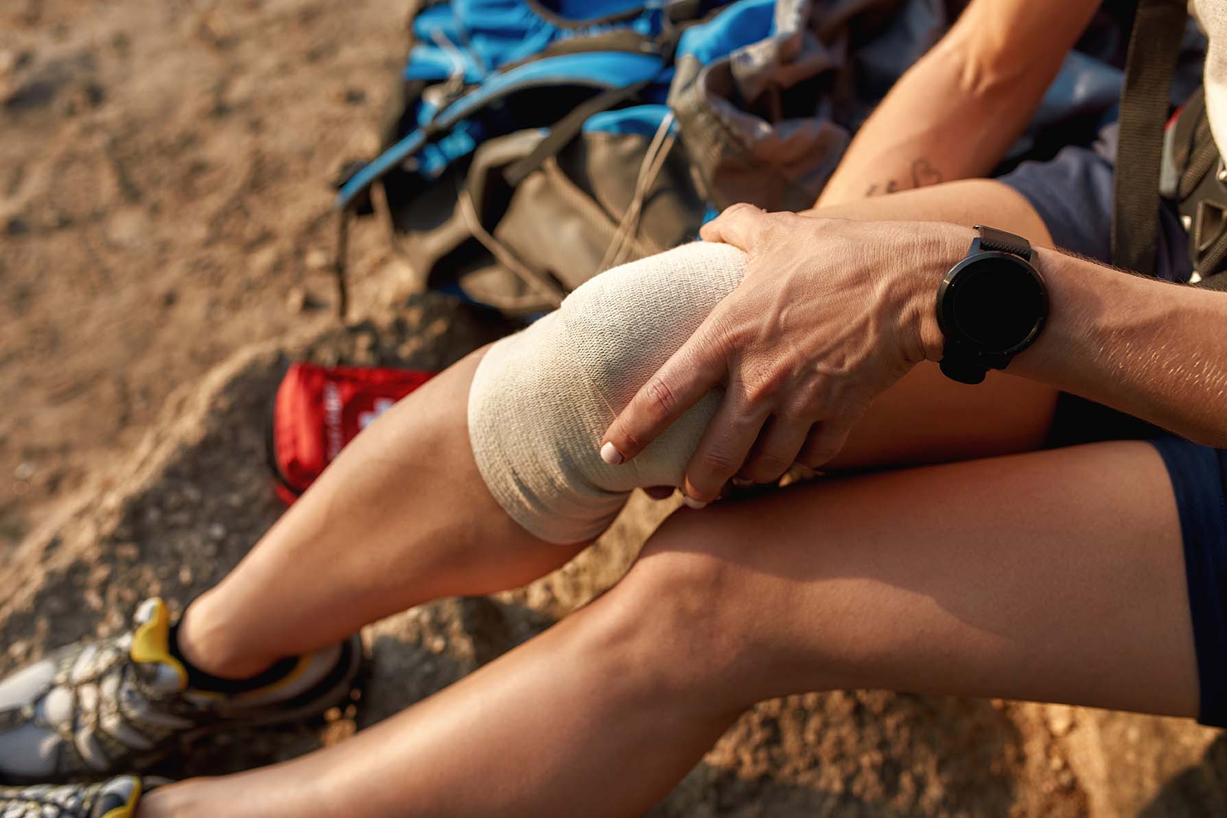 applying a bandage to a hiker's leg