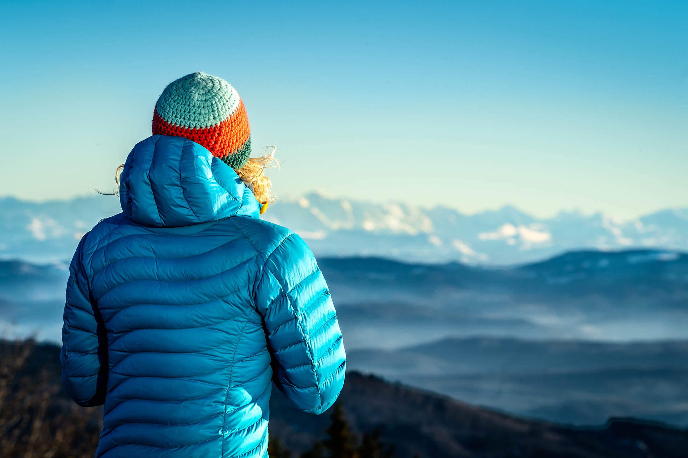 hiker wearing puffer jacket admiring mountains