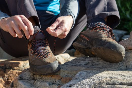 Climber lacing up approach shoes