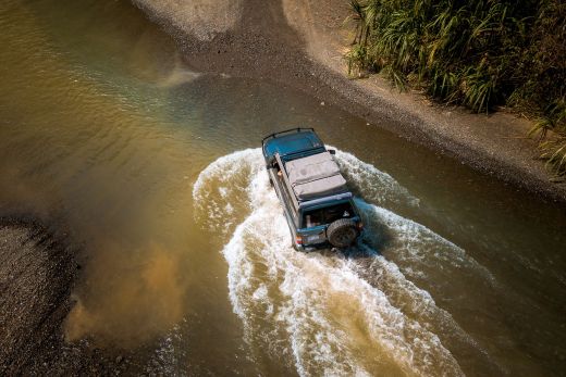 SUV driving through river